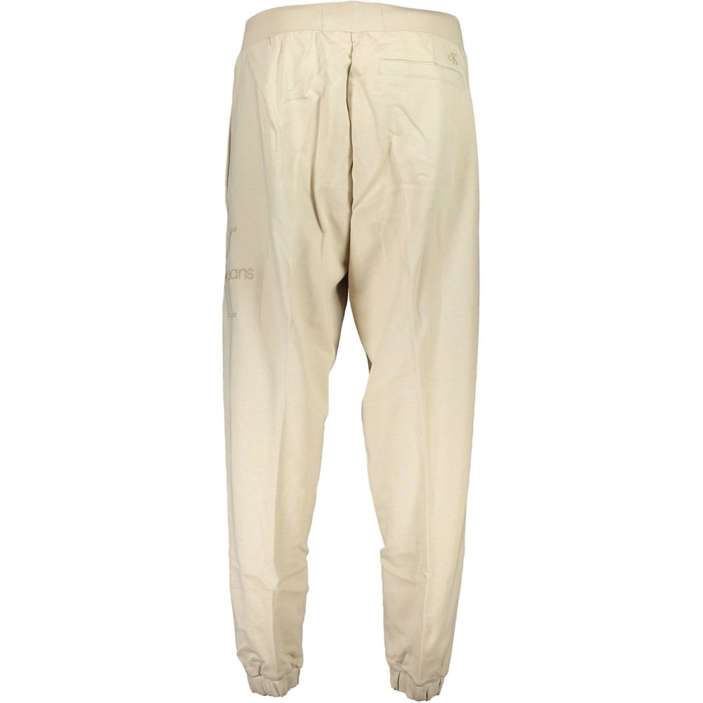 Calvin Klein Beige Cotton Pant featuring sports design, elastic waist and ankles, 3 pockets, and logo embroidery, made of 50% transitional cotton.