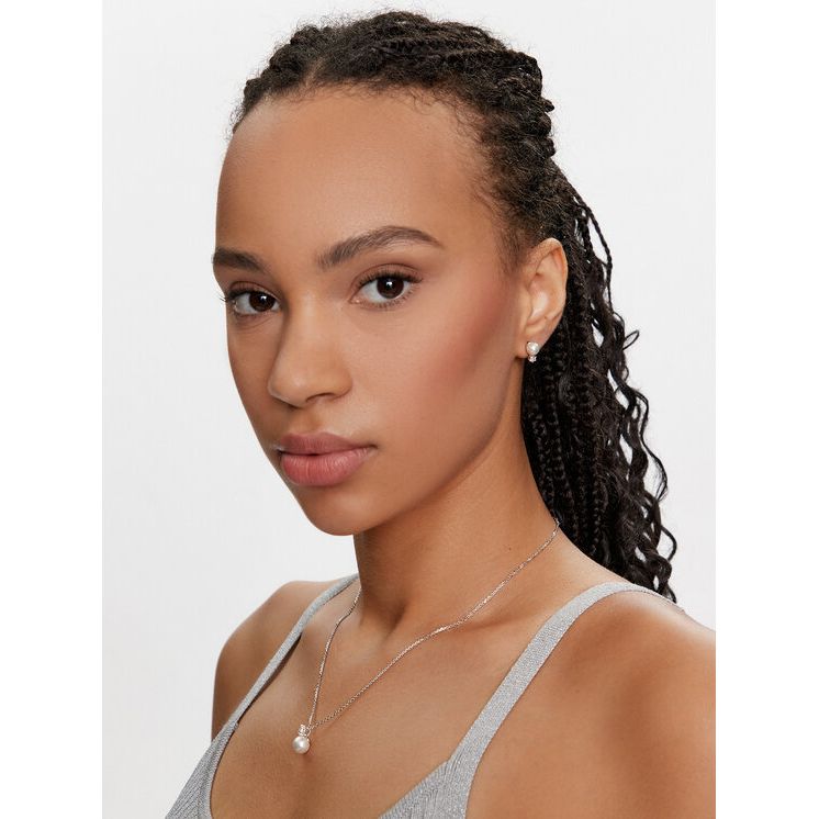 Woman wearing SWAROVSKI Mod. 5689624 silver earrings and necklace, highlighting elegant jewelry for ladies with official packaging.