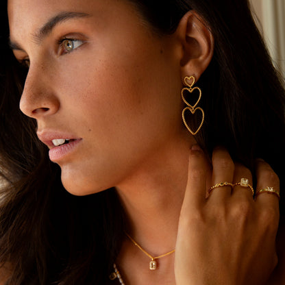 Model wearing 24KAE JEWELS JEWELRY Mod. 12472Y/52, featuring heart earrings, gold necklace, and rings.