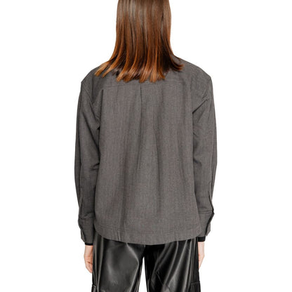 Back view of model wearing Jacqueline De Yong Black Recycled Cotton Blouse with long sleeves, showcasing relaxed fit and eco-friendly fabric.