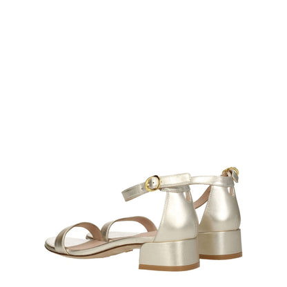 Stuart Weitzman Gold Leather Flat Sandals with buckle closure and mid heels, featuring metallic platinum color and open toe design.
