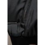 Close-up of Dolce & Gabbana Black Red Floral Silk Bomber Blouson Jacket showing detail of black fabric and zipper.