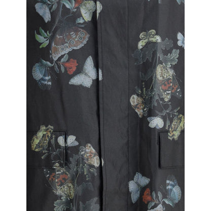 Close-up of butterfly print on Undercover Black Cotton Coat for AW25, featuring waxed fabric and practical flap pockets.