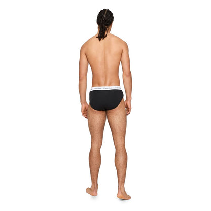 Man wearing Calvin Klein Underwear Black And White Cotton Briefs, showcasing elastic waistband and comfortable fit, rear view.
