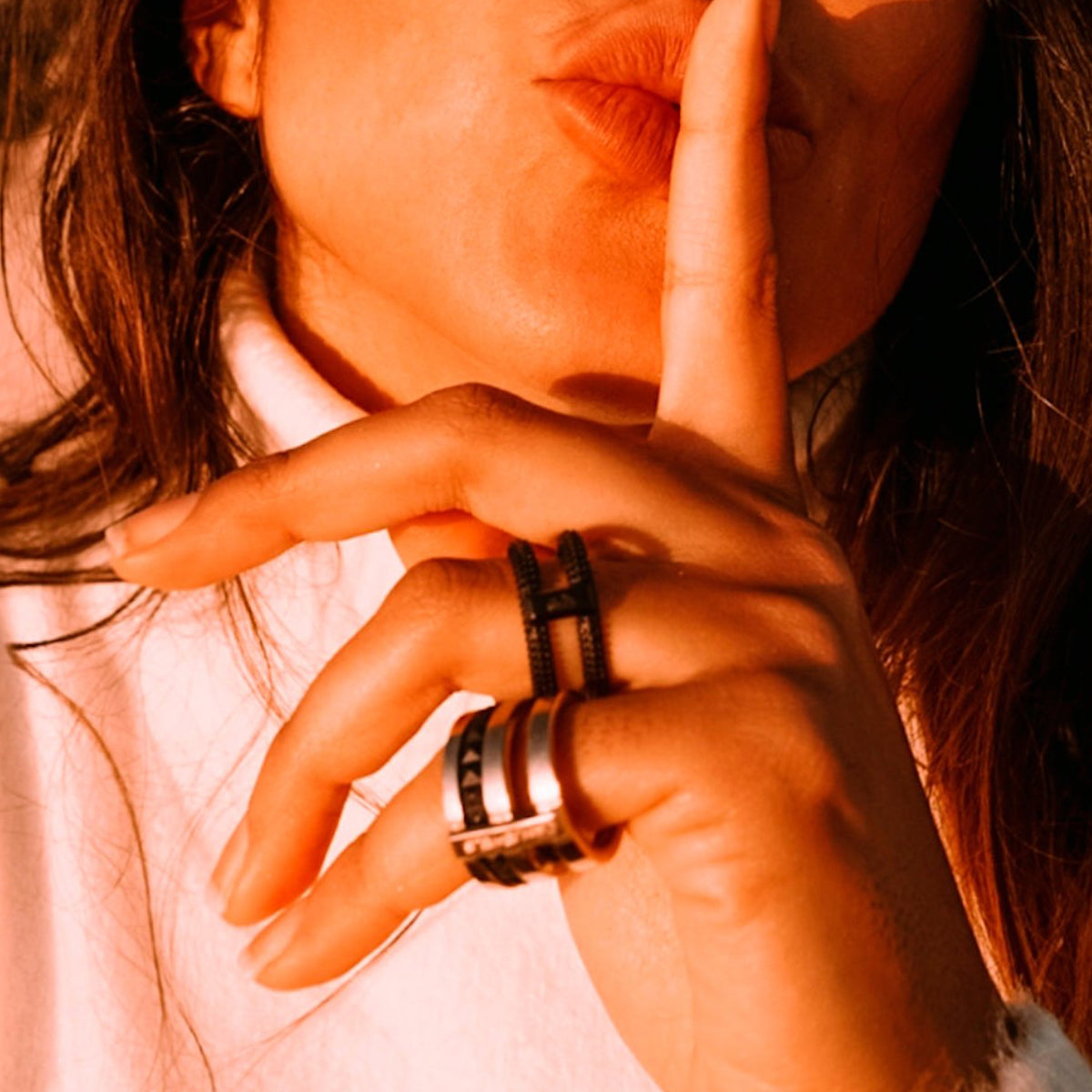 Woman wearing AN JEWELS JEWELRY Mod. AR.R2NS02BK-9 rings, shushing with finger on lips