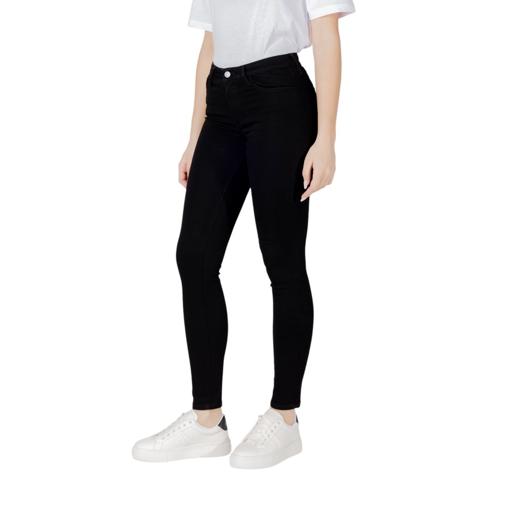 Woman wearing Armani Exchange Black Cotton Skinny Jeans with white sneakers and white t-shirt