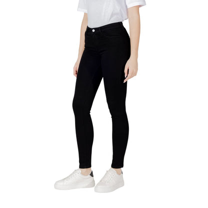 Woman wearing Armani Exchange Black Cotton Skinny Jeans with white sneakers and white t-shirt