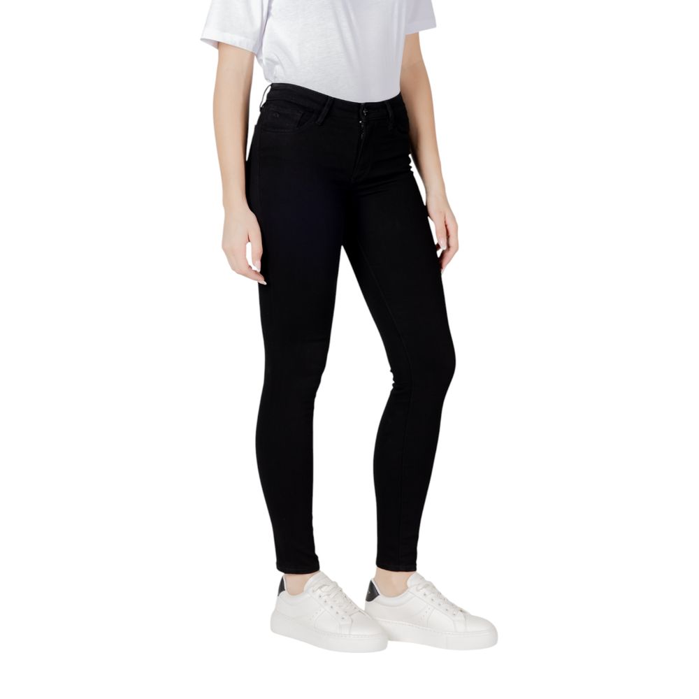 Woman wearing Armani Exchange Black Cotton Skinny Jeans with a white t-shirt and white sneakers.
