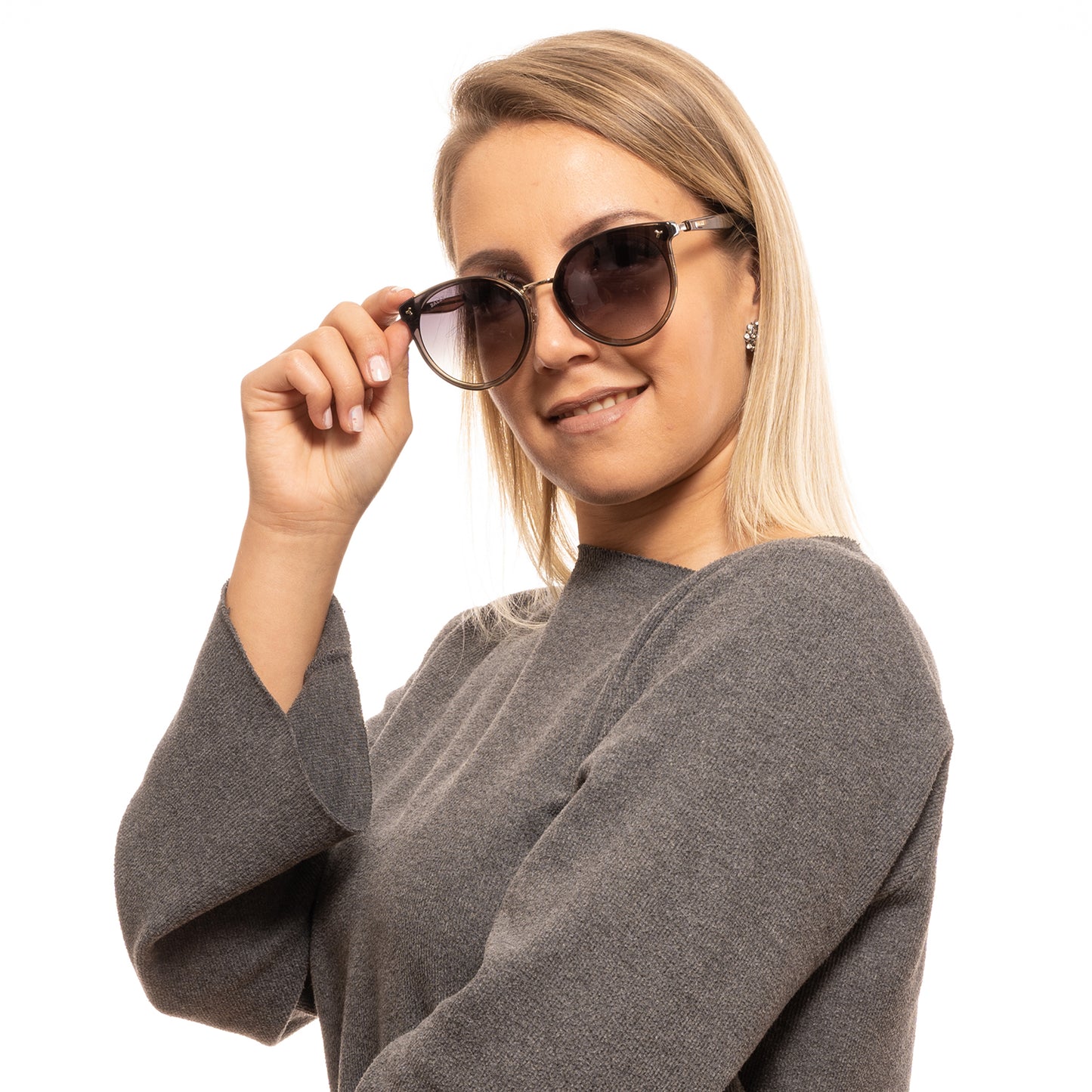 Lady wearing BALLY MOD. BY0043-K 6545B sunglasses, smiling and holding frames, official packaging available.