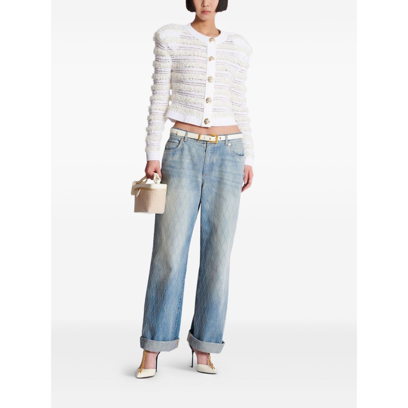 Model wearing Balmain Long-sleeved tweed-effect knit cardigan with ribbed trim and pinched shoulders, paired with wide-legged jeans.