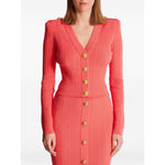 Coral pink Balmain long-sleeved twisted knit cardigan with gold logo-embossed buttons and plunging V-neck.