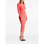 Balmain Long-sleeved twisted knit cardigan in coral pink with button fastening modeled, featuring logo-embossed buttons and V-neck design.