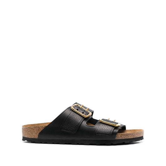 Birkenstock Double-strap leather sandals in black with gold-tone hardware and a flat rubber sole, featuring a branded footbed and narrow width.