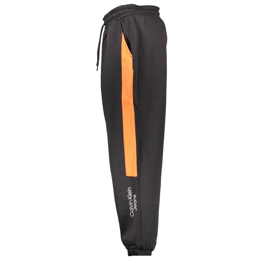Calvin Klein Black Cotton Pant with elastic waistband, laces, ankle cuffs, side pockets, embroidery, contrasting orange detail, logo.