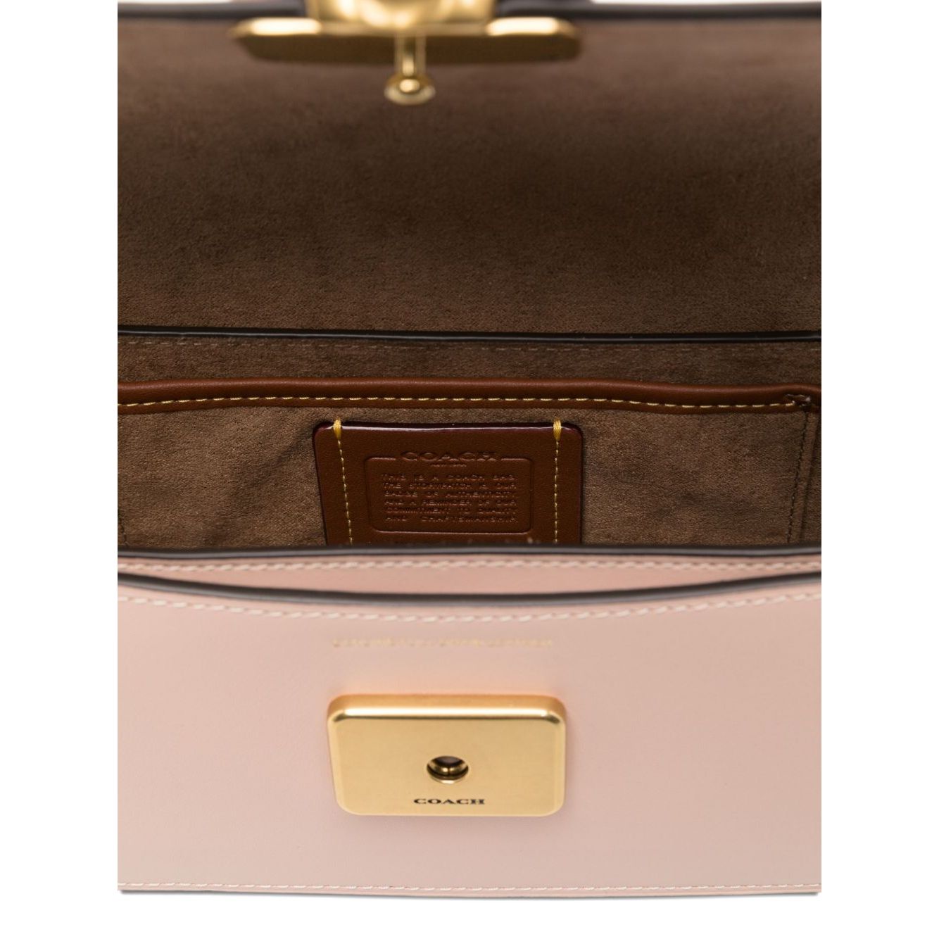 Interior view of a cream Coach Zoe leather shoulder bag with gold-tone clasp and brown lining, highlighting spacious inner compartment.