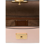 Interior view of a cream Coach Zoe leather shoulder bag with gold-tone clasp and brown lining, highlighting spacious inner compartment.