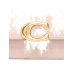 Coach Zoe leather shoulder bag with cream leather and gold-tone clasp detail, showing the elegant C logo on the front.