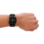 Person wearing DIESEL Mod. CLIFFHANGER wristwatch with black leather strap and 40mm SS IP brown case on left wrist, showing watch face detail.