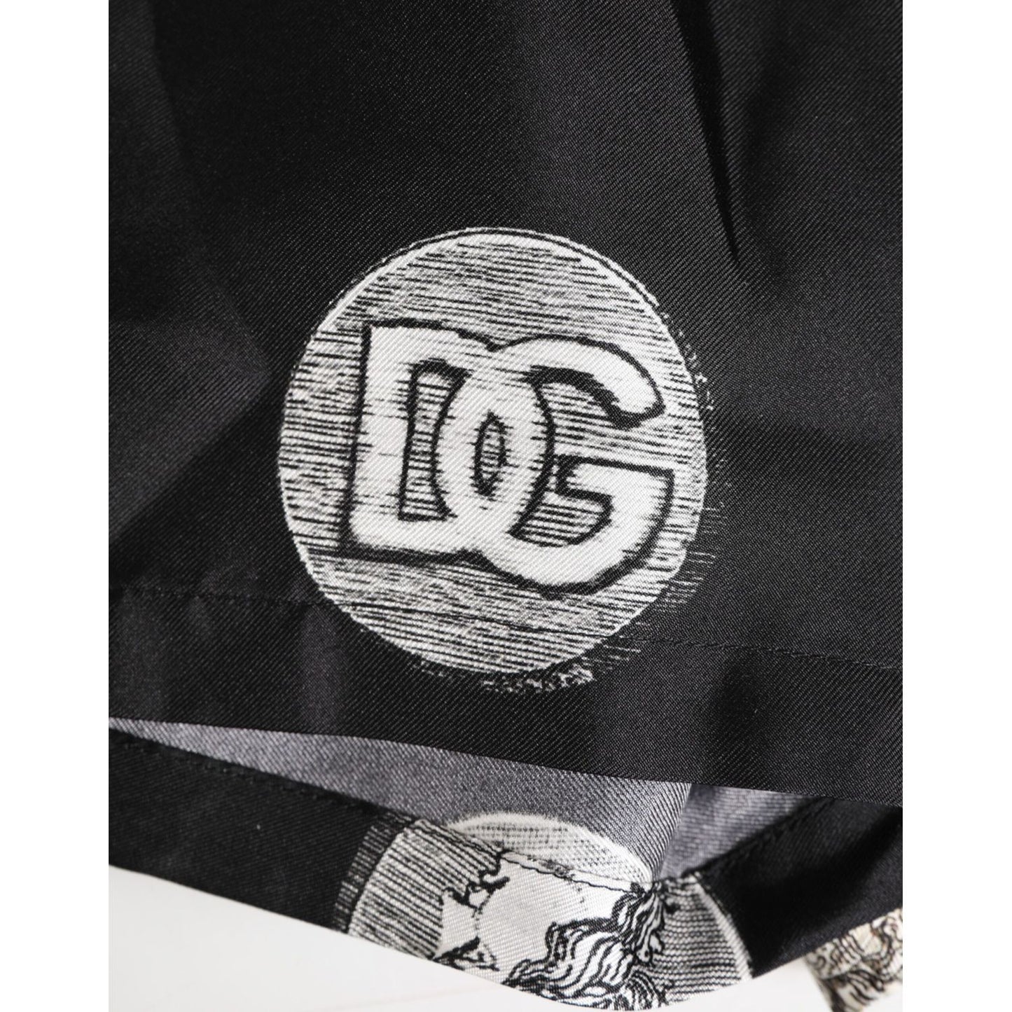 Close-up of Dolce & Gabbana Black Silk Ancient Coin Print Boxer Short Swimwear showcasing logo detail and coin design.