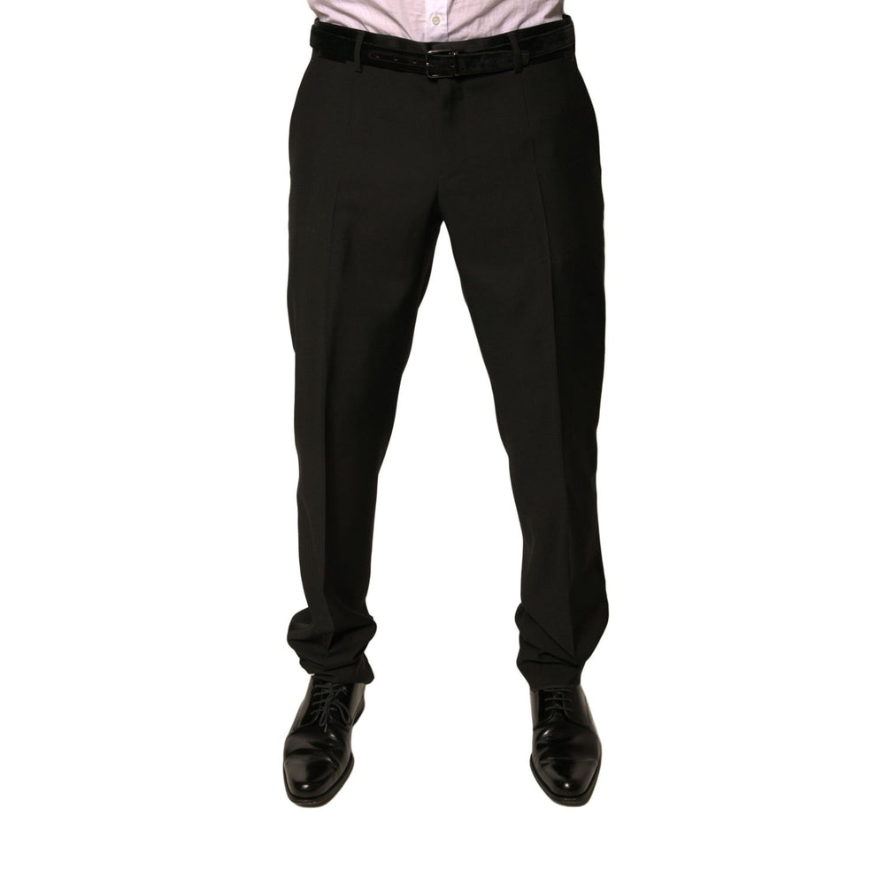Model wearing Dolce & Gabbana Black Wool Tapered Formal Dress Pants with button and zipper closure; high craftsmanship and luxurious design.
