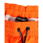 Dolce & Gabbana Orange Polyester Beachwear Men Shorts Swimwear with drawstring waistband and logo detailing.