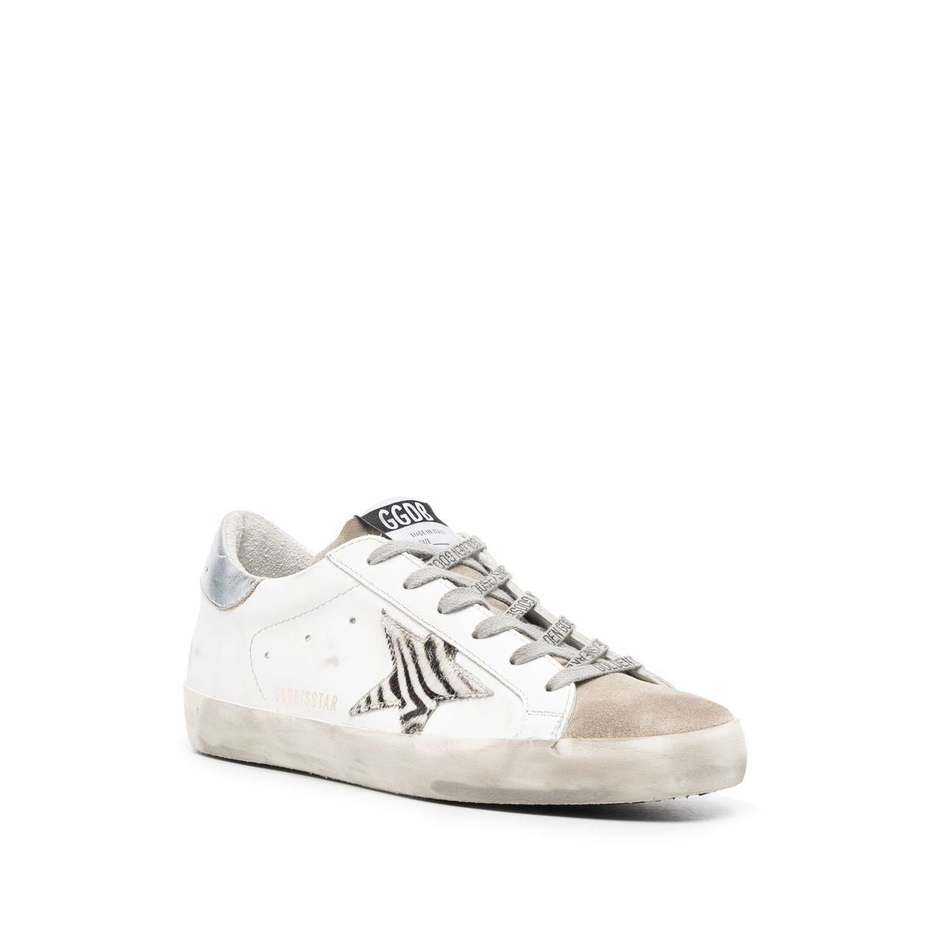 Golden Goose Super Star low-top sneaker with star patch, metallic heel, white leather, and flat rubber sole.