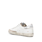 Golden Goose Super Star low-top sneaker with metallic heel and star patch, featuring cloud white leather and flat rubber sole.