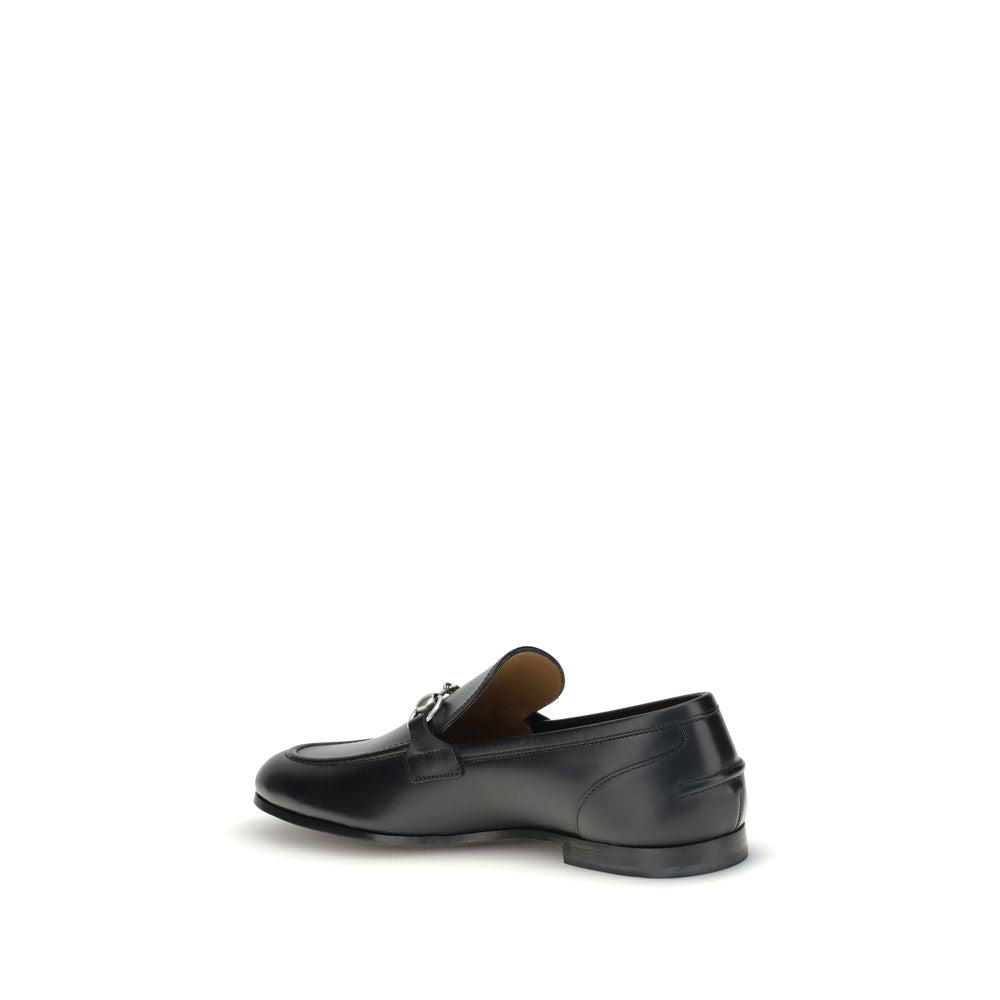 Gucci Black Calf Leather Bos Taurus Slip-On Loafers with metallic Morsetto detail and embossed logo, side view.