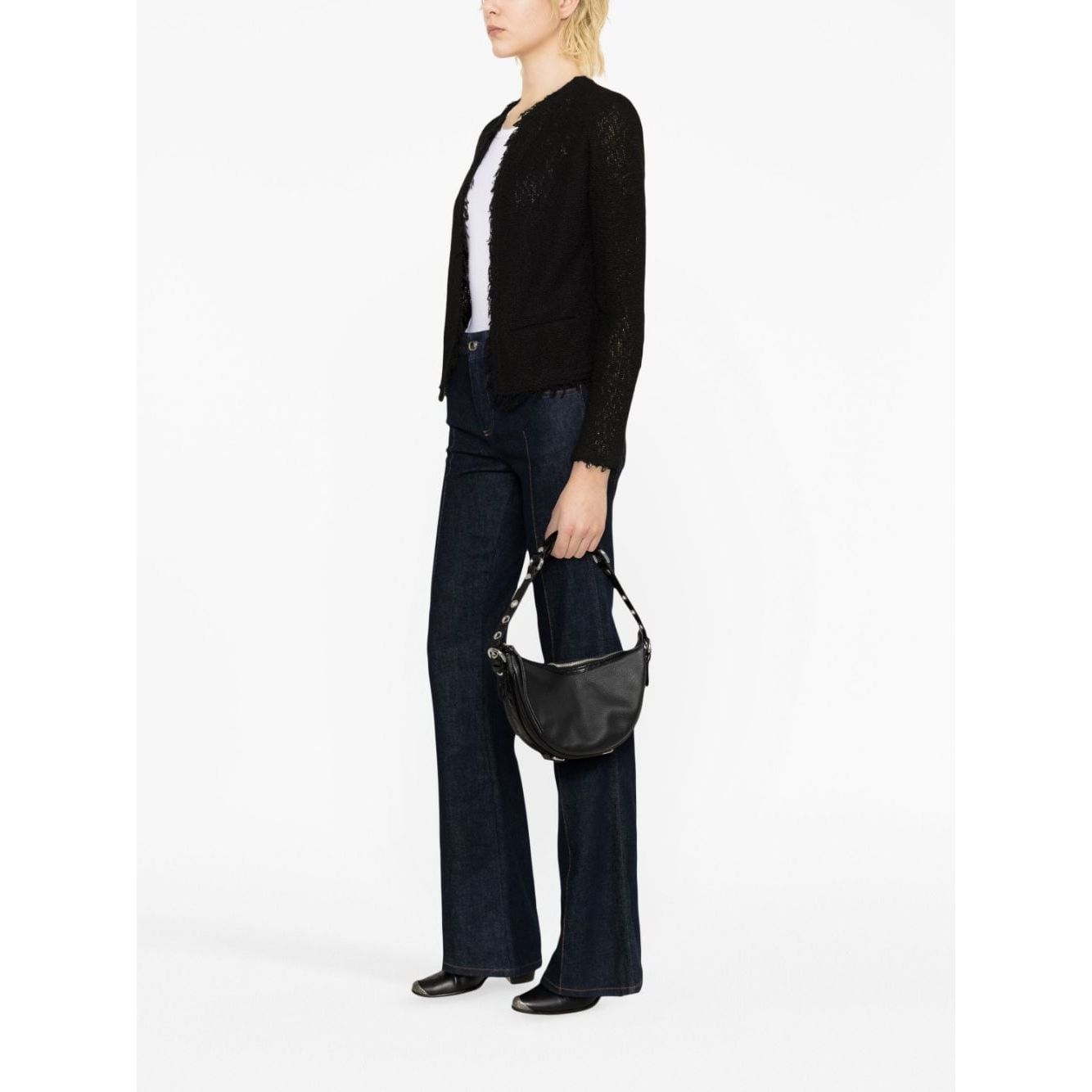Model wearing Iro Jackets Black with cotton blend, fringe detailing, round neck, and open front, styled with dark denim jeans.