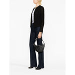 Model wearing Iro Jackets Black with cotton blend, fringe detailing, round neck, and open front, styled with dark denim jeans.