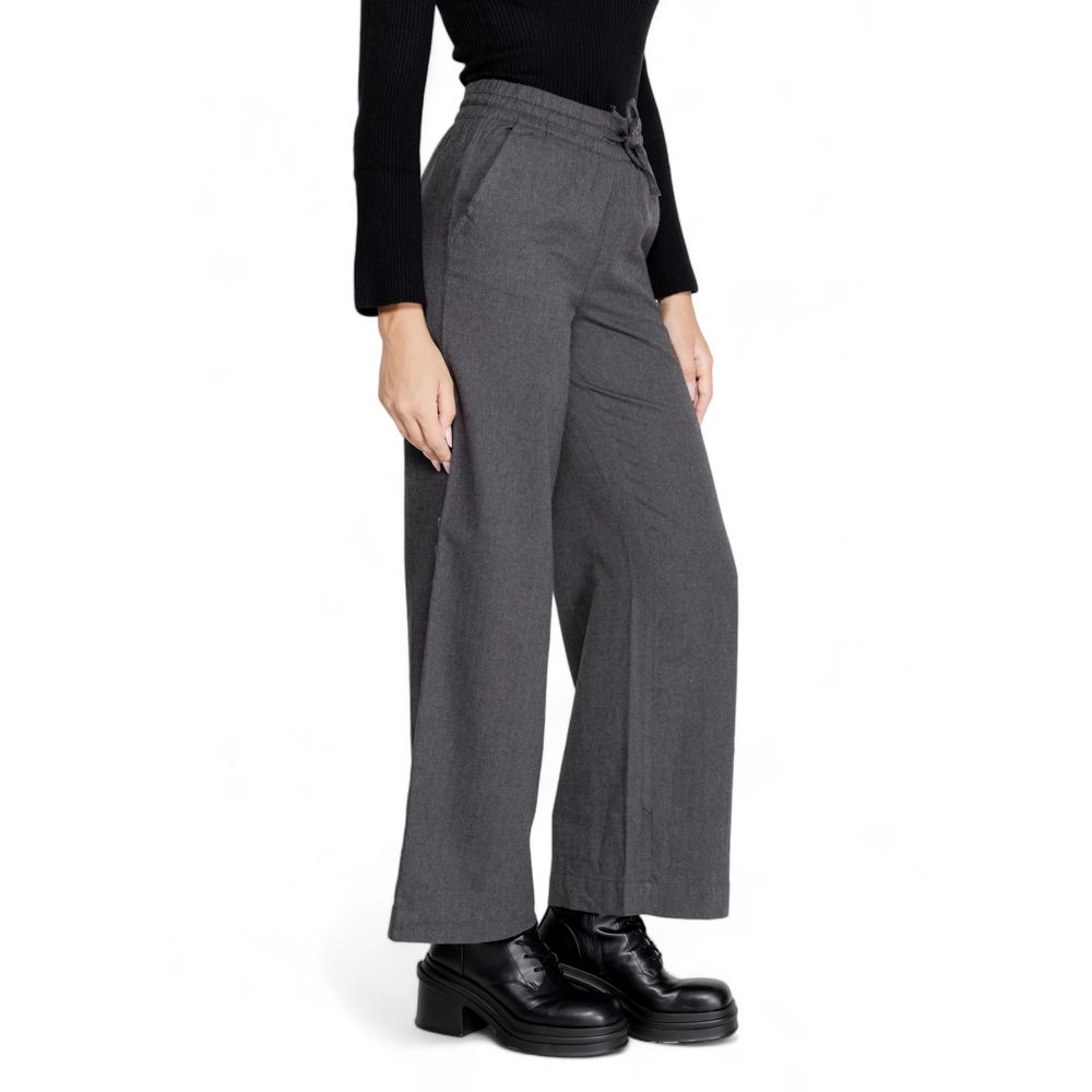 Woman wearing Jacqueline De Yong Gray Cotton Casual Pants with wide leg design and high waist, paired with black boots and top.