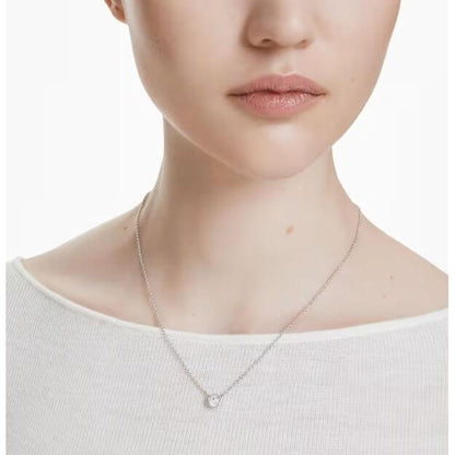 Elegant woman wearing Swarovski Mod. 5696039 Imber pendant necklace, round cut, rhodium plated, minimalist design.