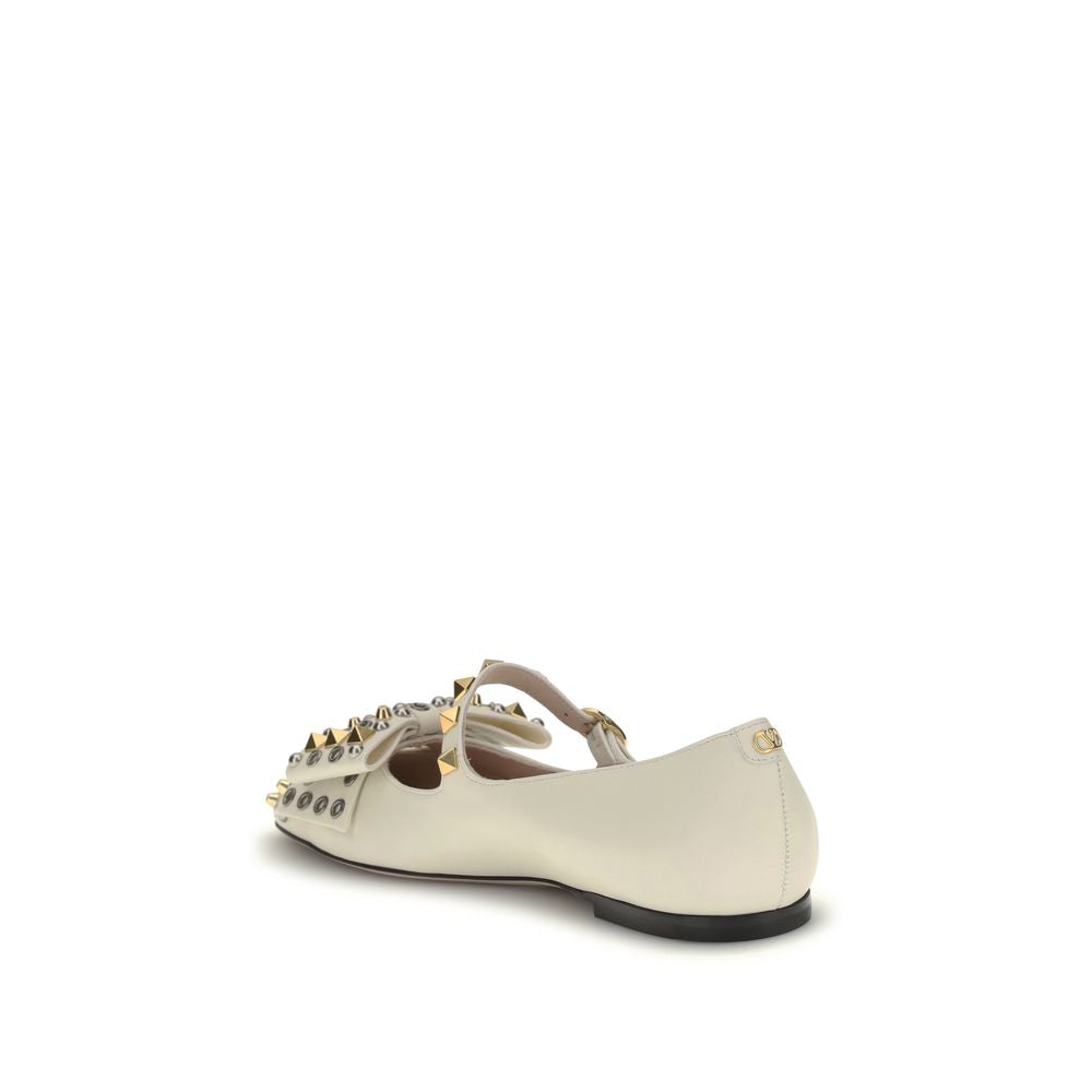 Valentino Garavani Cream Goatskin Ballet Flats with bow, eyelets, and antique-effect brass studs.