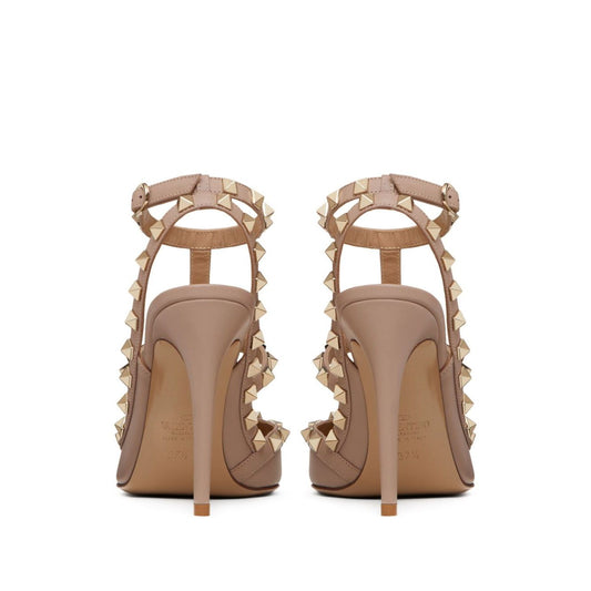 Back view of Valentino Garavani Rockstud Décolleté With 100mm Straps in powder pink leather featuring gold-tone Rockstud detailing and 100mm heels.