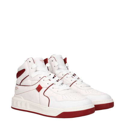 Valentino Garavani White Leather High Top Sneakers with red details, lace-up closure, studs, front and side logos, and rubber sole.
